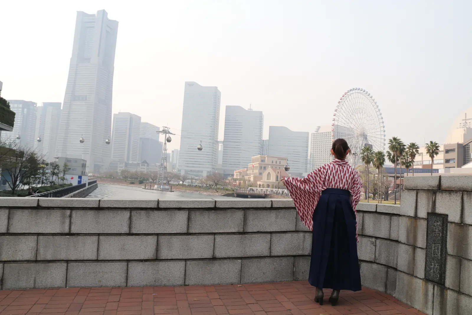 A woman in hakama looking toward Minato Mirai from Bankoku Bridge